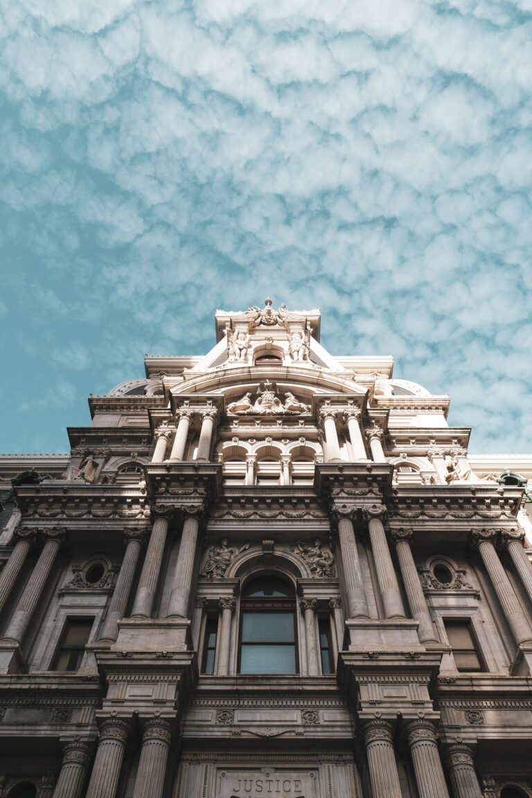 Exterior of a large municipal city hall building under a cloudy sky